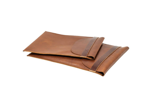 Two brown leather laptop sleeves on a white background, one small, one large. 