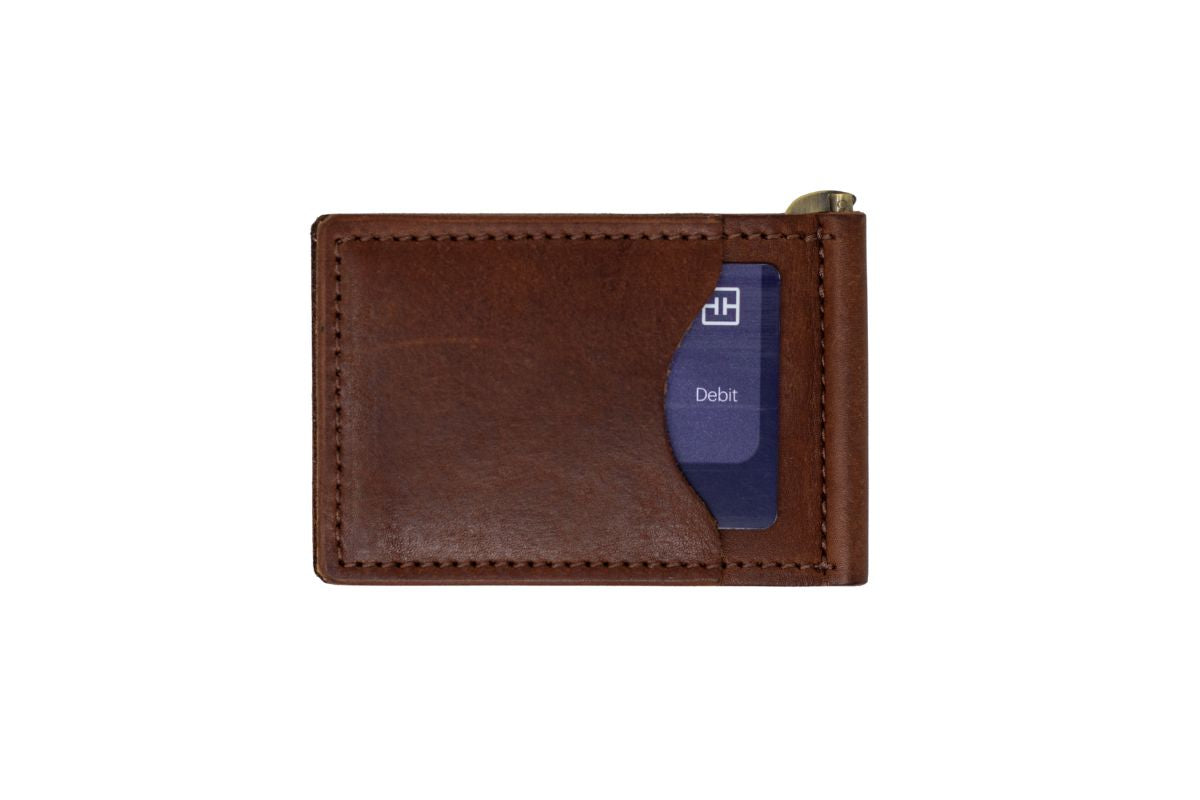 The back view of a brown leather bifold money clip wallet, with a white background, a credit card in the exterior card slot. 