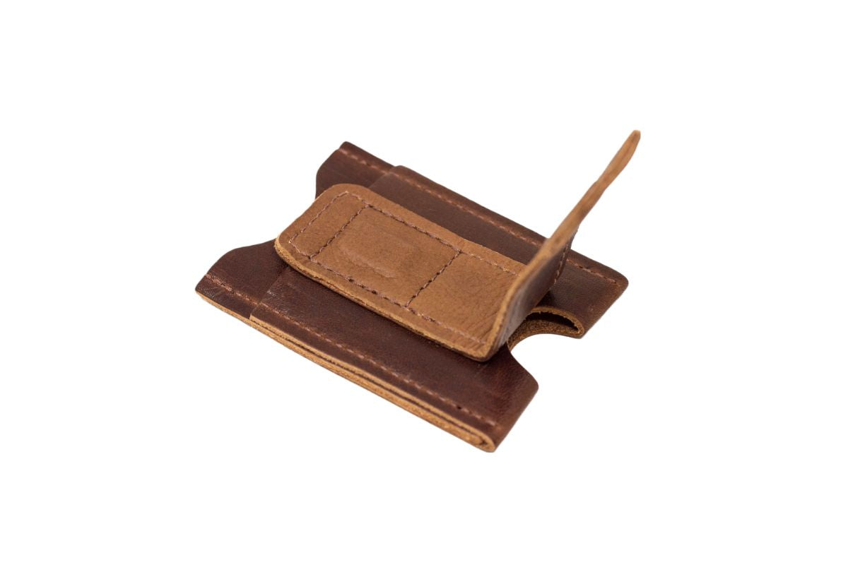 Brown leather wallet, with a magnetic money clip open. 