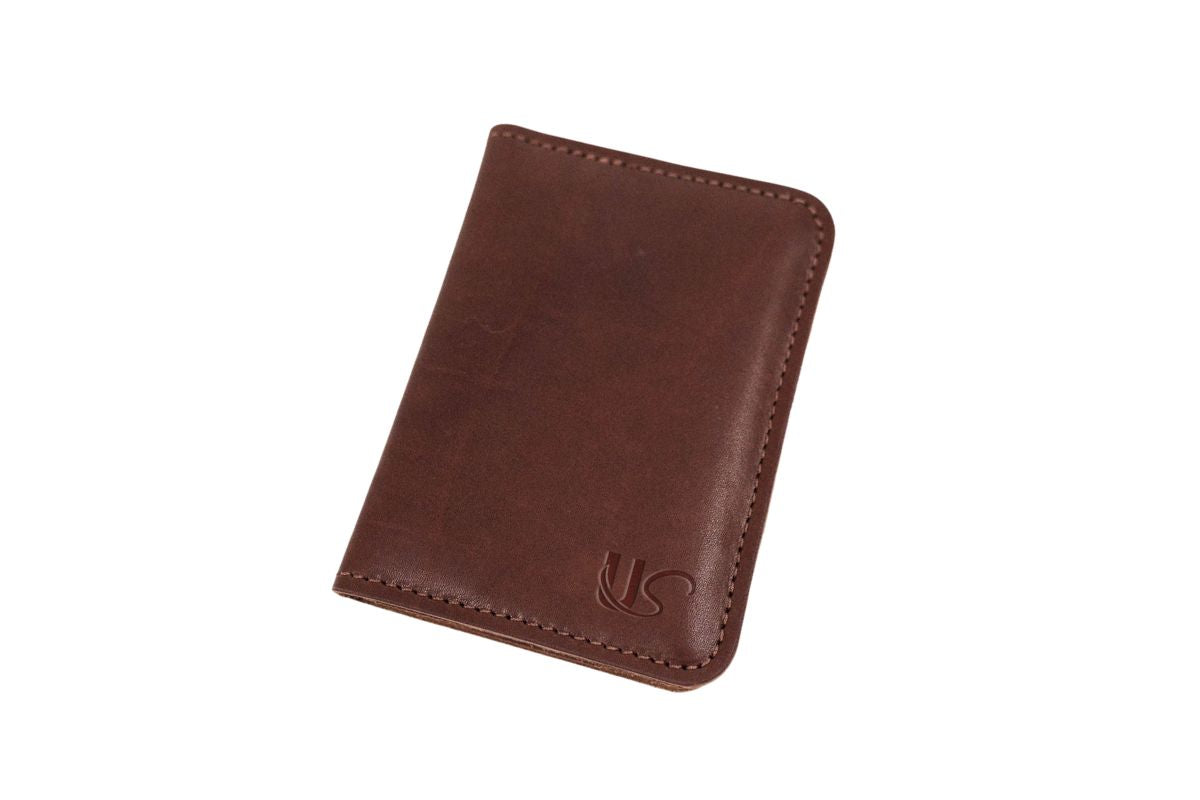The exterior of a brown leather passport wallet with a US logo on a white background