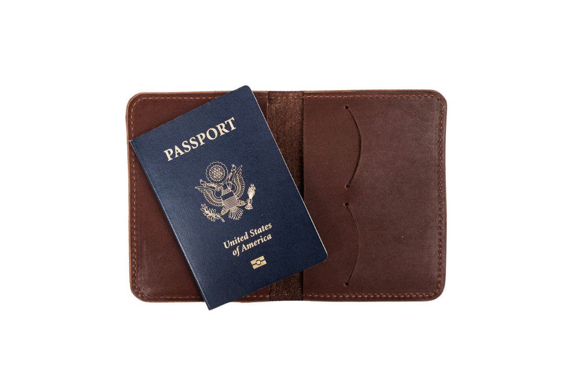 Interior of a brown leather passport wallet with a blue U.S. passport on a white background