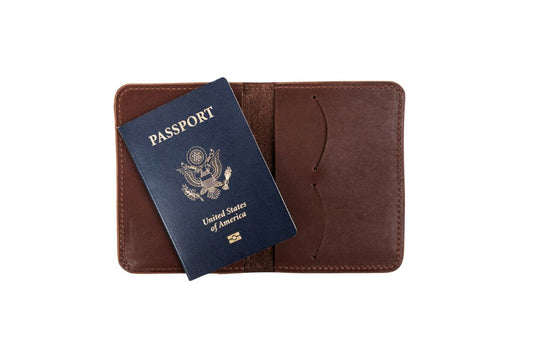 Interior of a brown leather passport wallet with a blue U.S. passport on a white background