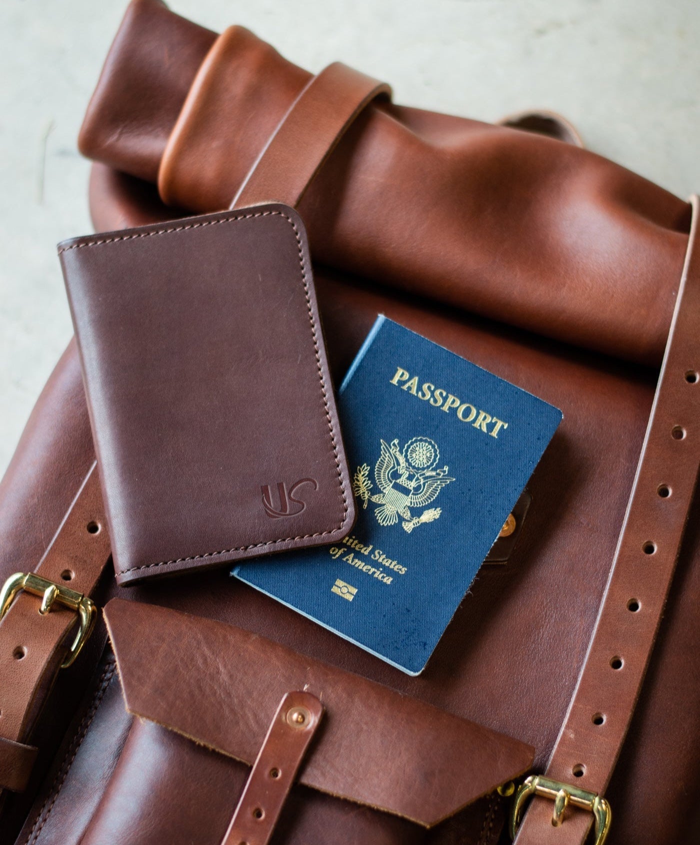 Brown leather wallet and passport on a brown leather bag
