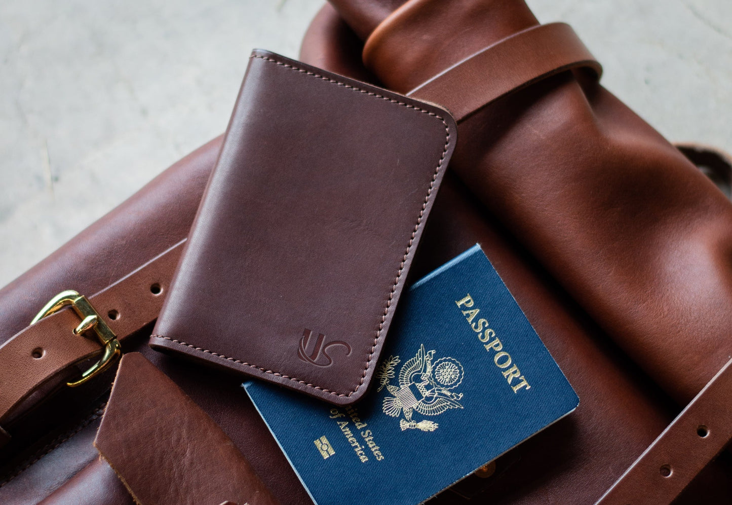 Brown leather passport holder on a brown leather bag with a passport