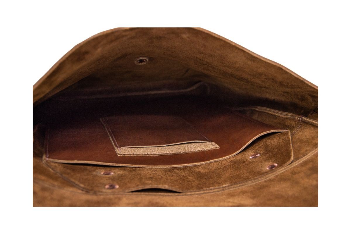 Close-up of the interior pockets inside a brown leather rucksack.