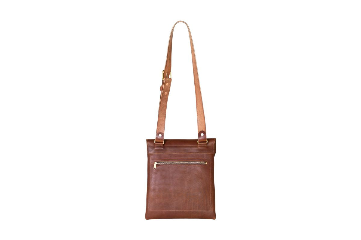 Brown leather courier bag, showcasing the back zipper pocket. 