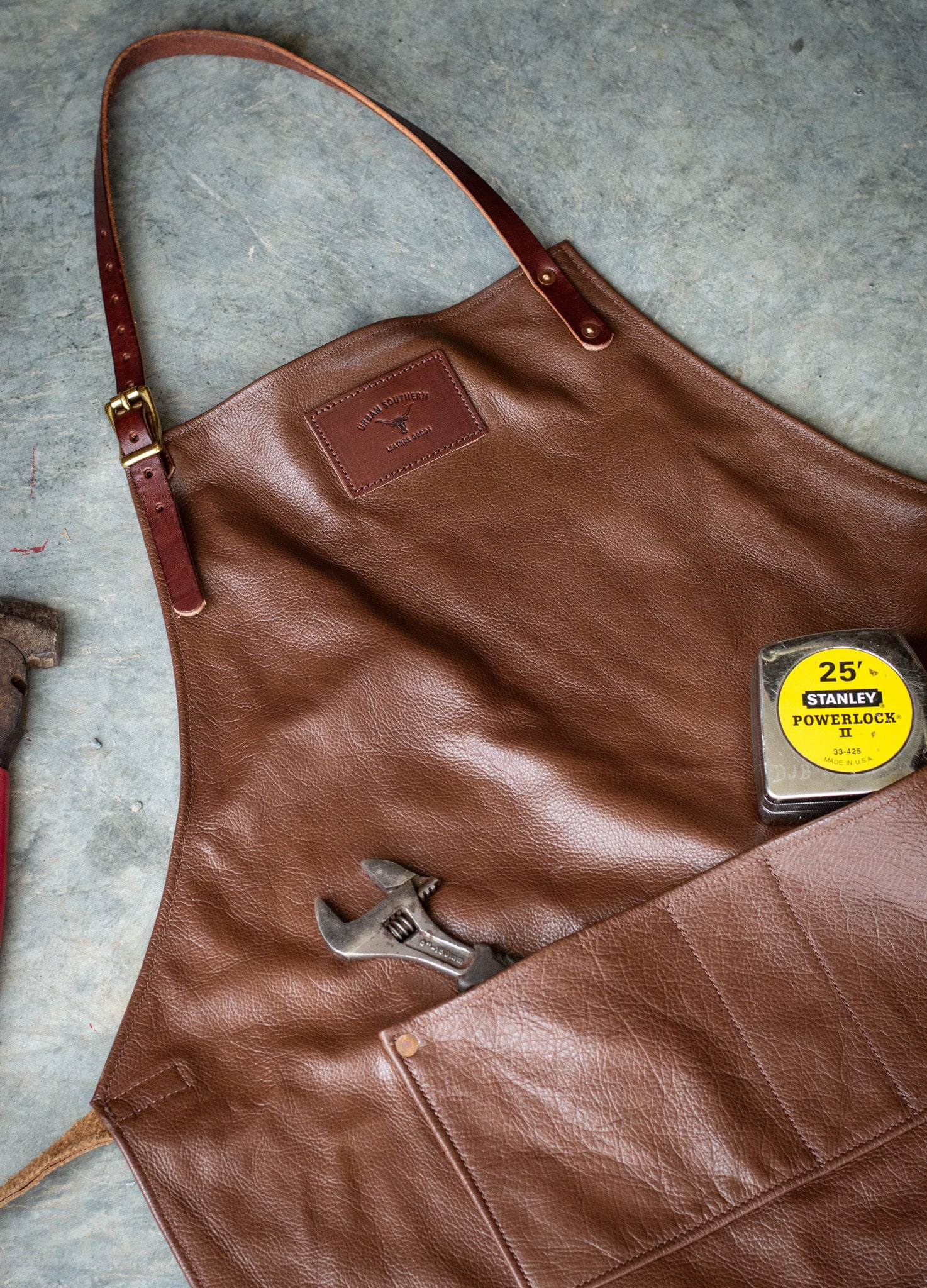 Brown leather apron with tools sticking out of the front pockets