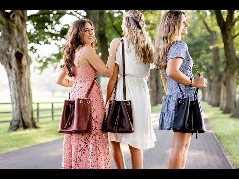 Video tour demonstrating the features of the Urban Bucket Bag. A woman is showcasing the drawstring closure, zipper pocket, interior slip pocket & key fob. 