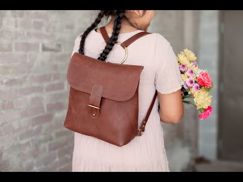Video tour demonstrating the features of the Monterey Backpack. A woman is showcasing the interior compartment, slip pockets, key fob & brass ring with adjustable straps. 