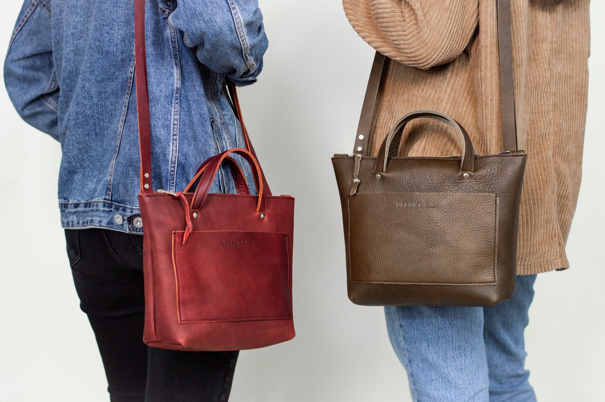 Two women wear Quinn Crossbody handbags on their shoulders. 