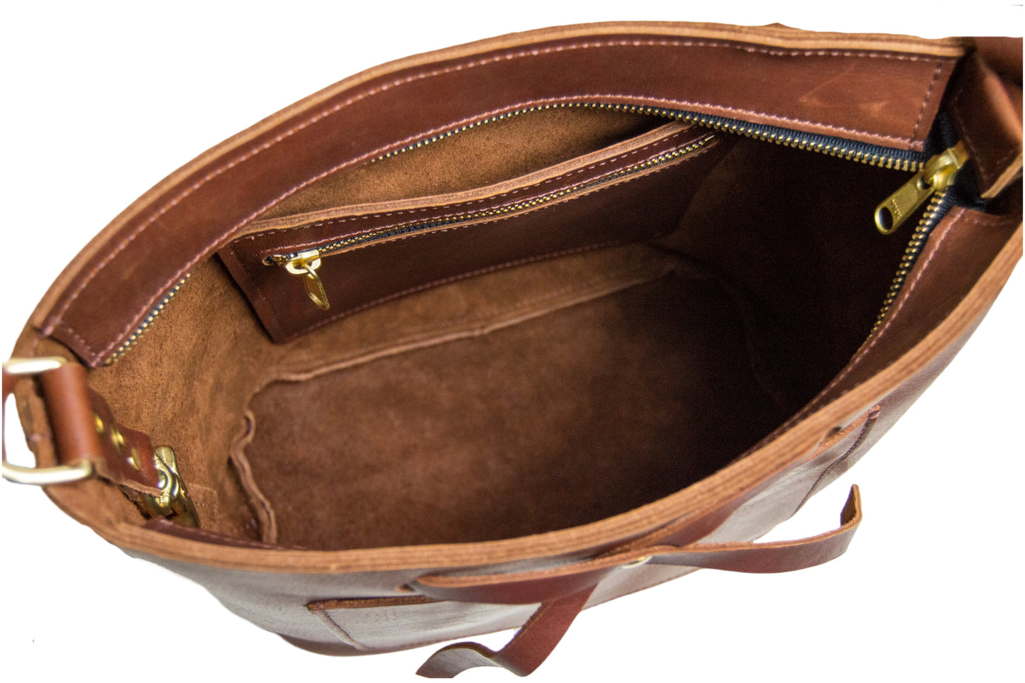 A view of the interior of the Lexington Bow handbag, featuring one slip pocket, one zipper pocket & a key fob. 