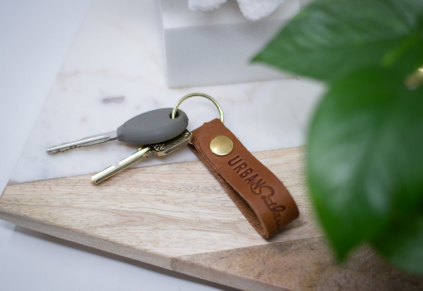 An Urban Key Fob in the color honey, sits on an entryway table.