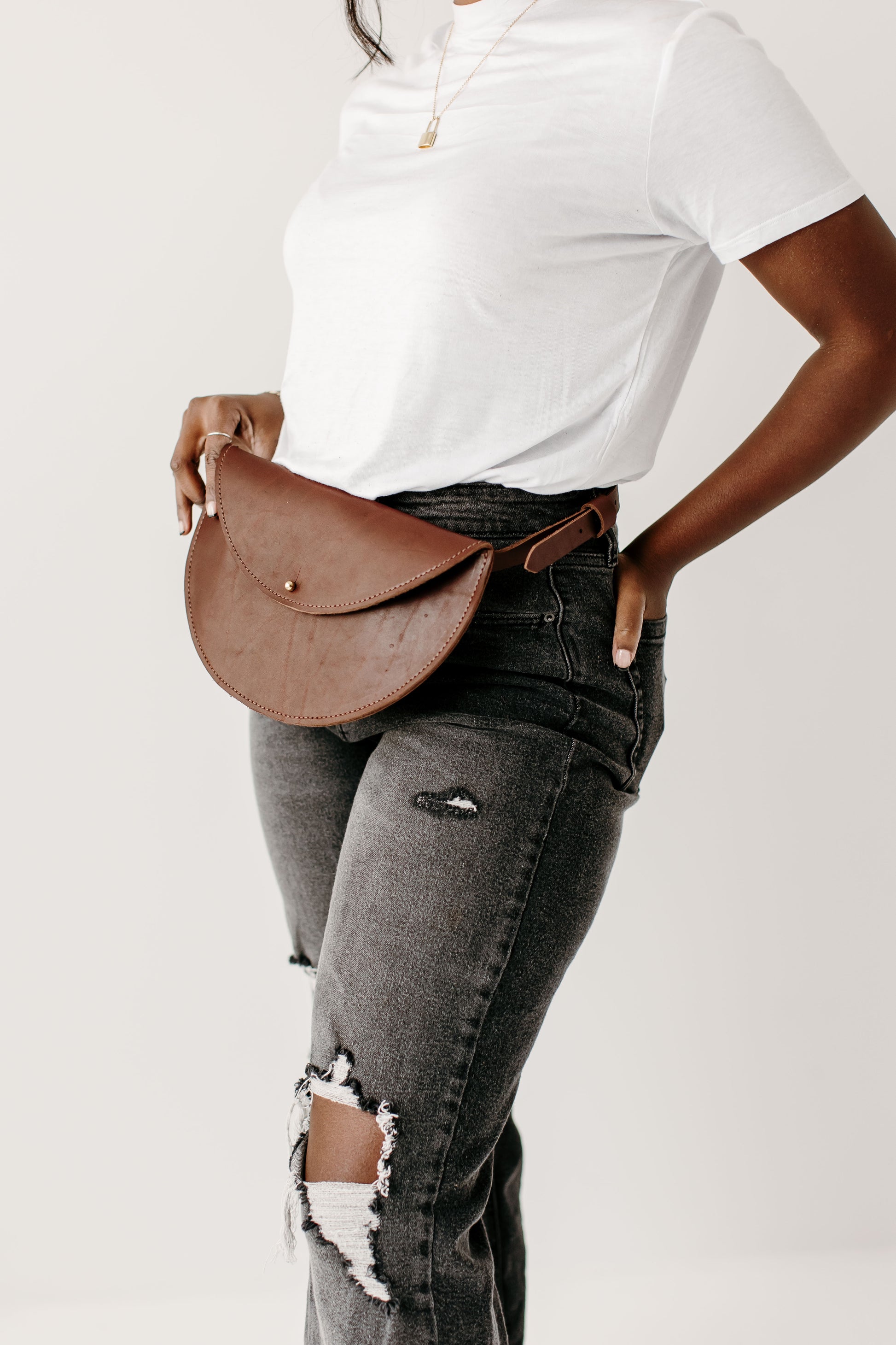 A woman wears the Half Moon Belt Bag around her waist.