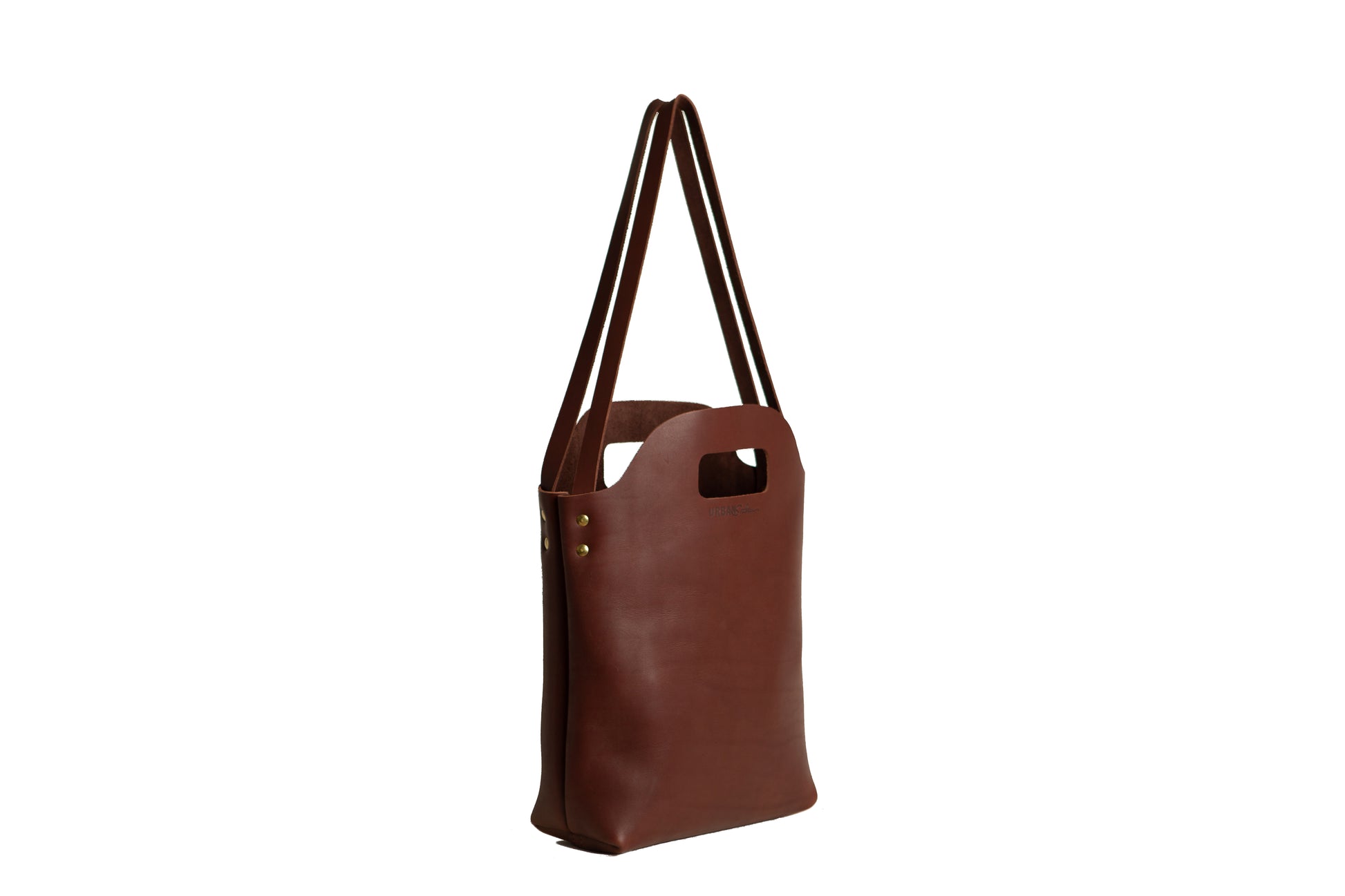 The Urban Southern handcrafted leather Mini Market Tote features brass accents and the Urban Southern logo engraved on the front.